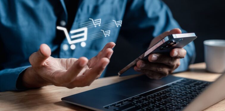 Pessoa fazendo vendas online pelo celular, com ícones de carrinhos de compras sobre a imagem, destacando a importância do e-commerce no Brasil.