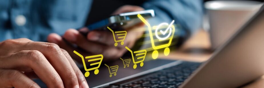Pessoa utilizando laptop e smartphone para vender online, com ícones de carrinho de compras digital representando comércio eletrônico e compras na internet.